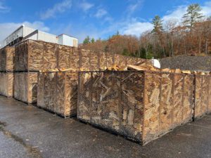 This image shows large wire mesh cubes full of seasoning firewood.