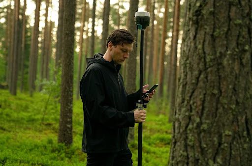 Land surveyor using new technology to assess forest