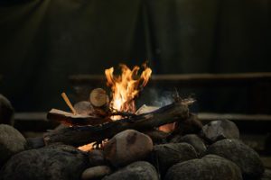 Log cabin fire with a ring of stones